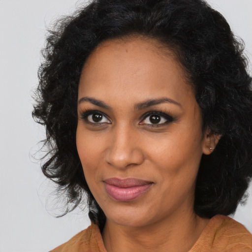 Joyful black young-adult female with long  brown hair and brown eyes