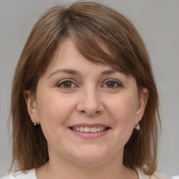 Joyful white adult female with medium  brown hair and grey eyes