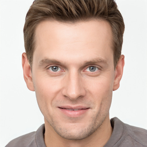 Joyful white young-adult male with short  brown hair and grey eyes