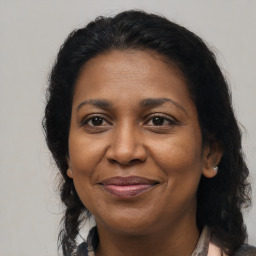 Joyful black adult female with long  brown hair and brown eyes