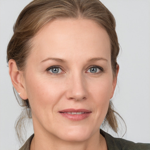 Joyful white adult female with medium  brown hair and blue eyes