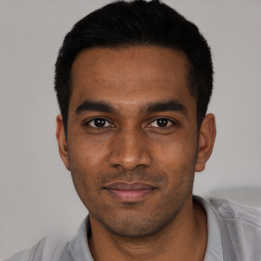 Joyful black young-adult male with short  black hair and brown eyes