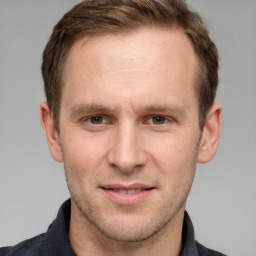 Joyful white adult male with short  brown hair and grey eyes