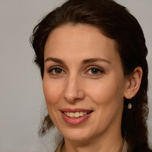 Joyful white adult female with medium  brown hair and green eyes