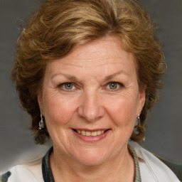 Joyful white adult female with medium  brown hair and blue eyes