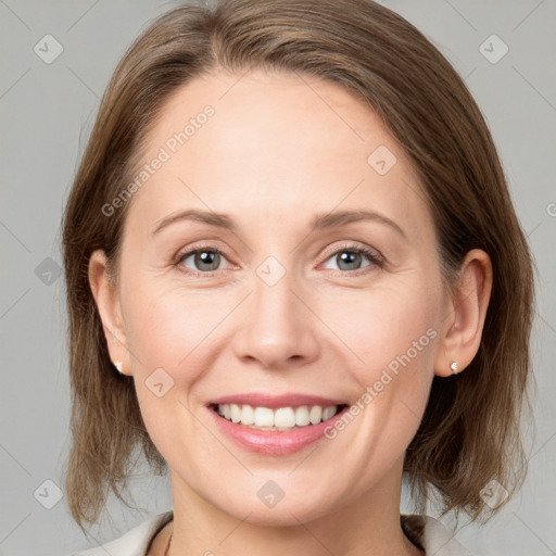 Joyful white adult female with medium  brown hair and grey eyes