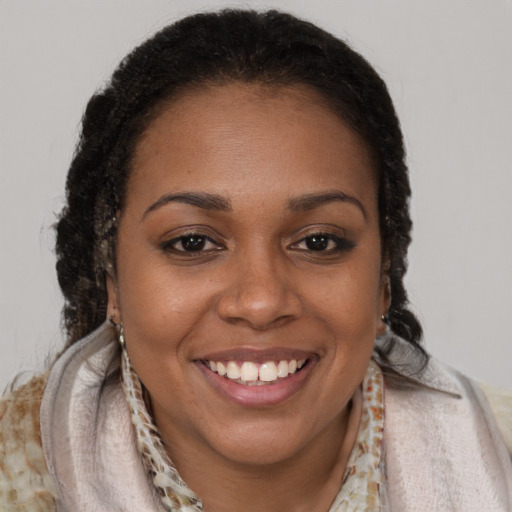 Joyful black young-adult female with long  brown hair and brown eyes