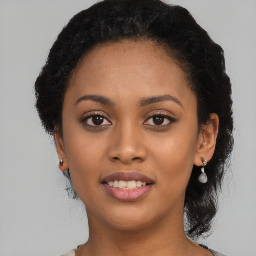 Joyful black young-adult female with short  black hair and brown eyes