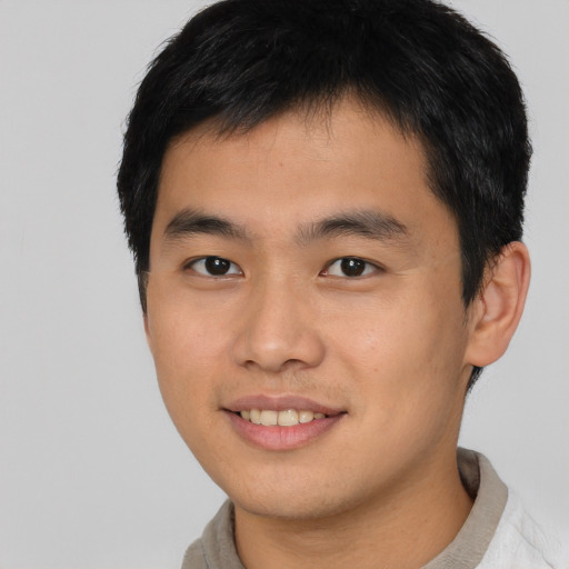 Joyful asian young-adult male with short  black hair and brown eyes