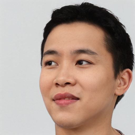 Joyful asian young-adult male with short  black hair and brown eyes