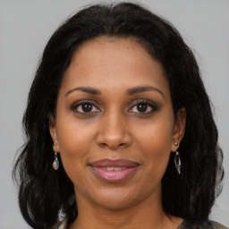 Joyful black adult female with long  brown hair and brown eyes