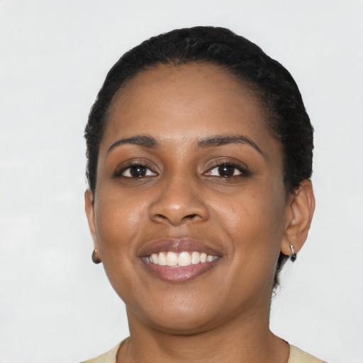 Joyful black young-adult female with short  black hair and brown eyes
