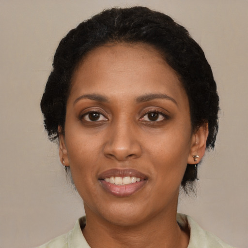 Joyful black young-adult female with medium  black hair and brown eyes