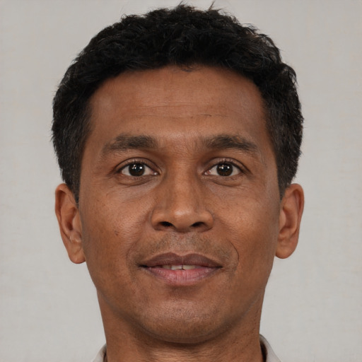 Joyful black adult male with short  brown hair and brown eyes