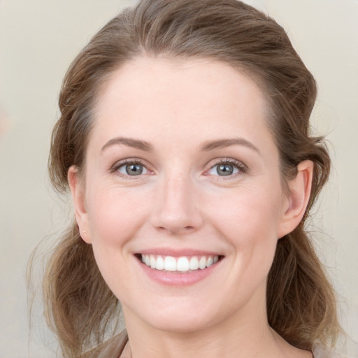 Joyful white young-adult female with medium  brown hair and blue eyes