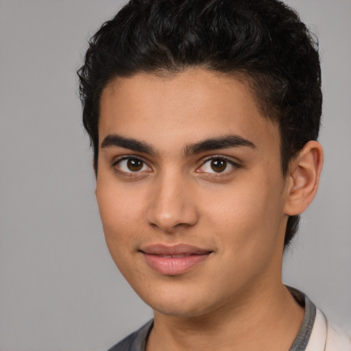 Joyful latino young-adult male with short  black hair and brown eyes