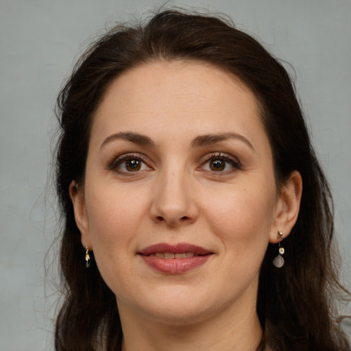 Joyful white adult female with long  brown hair and brown eyes