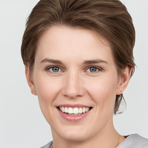 Joyful white young-adult female with short  brown hair and grey eyes