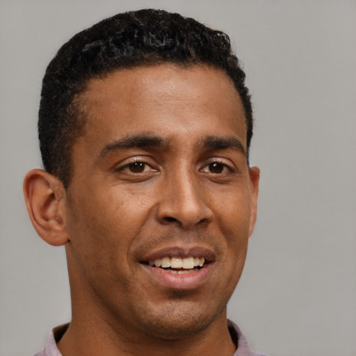 Joyful latino young-adult male with short  brown hair and brown eyes