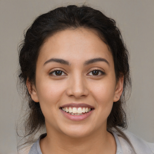 Joyful latino young-adult female with medium  brown hair and brown eyes