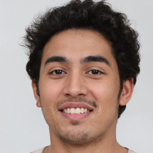 Joyful latino young-adult male with short  brown hair and brown eyes
