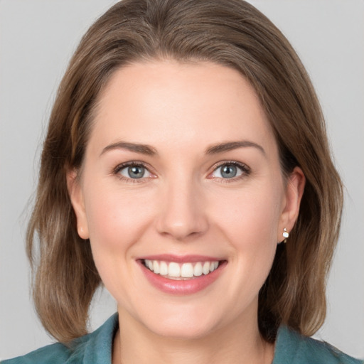 Joyful white young-adult female with medium  brown hair and grey eyes