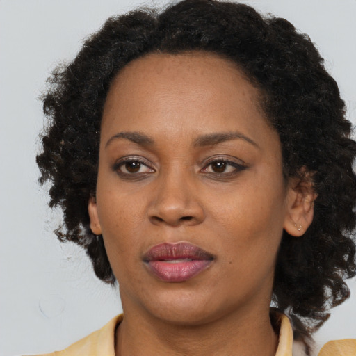Joyful black adult female with medium  brown hair and brown eyes