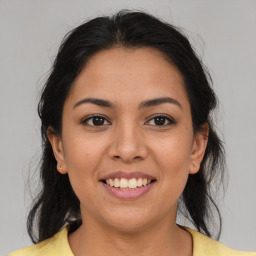 Joyful latino young-adult female with medium  brown hair and brown eyes