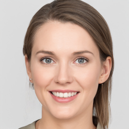 Joyful white young-adult female with medium  brown hair and grey eyes