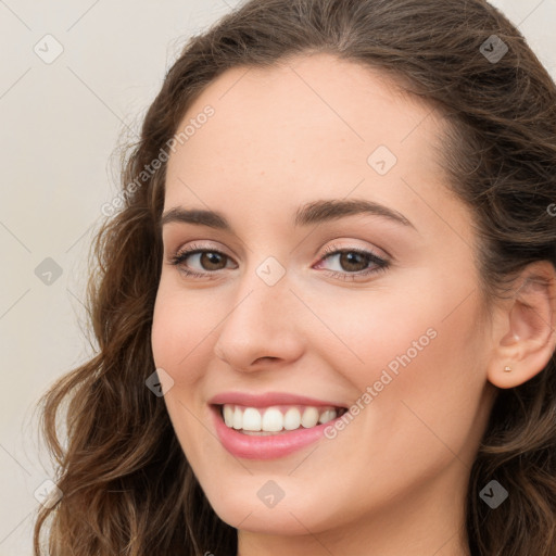 Joyful white young-adult female with long  brown hair and green eyes