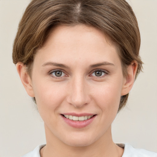 Joyful white young-adult female with short  brown hair and grey eyes