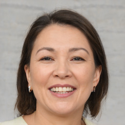 Joyful white adult female with medium  brown hair and brown eyes