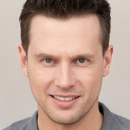 Joyful white adult male with short  brown hair and grey eyes