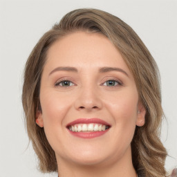 Joyful white young-adult female with long  brown hair and green eyes