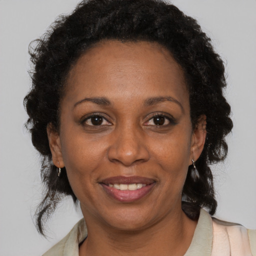 Joyful black adult female with medium  brown hair and brown eyes