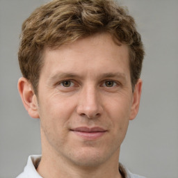 Joyful white adult male with short  brown hair and grey eyes