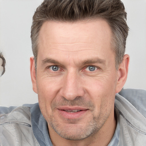 Joyful white adult male with short  brown hair and grey eyes