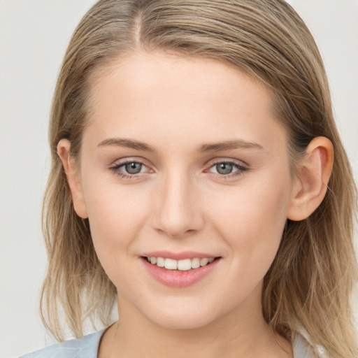 Joyful white young-adult female with long  brown hair and grey eyes