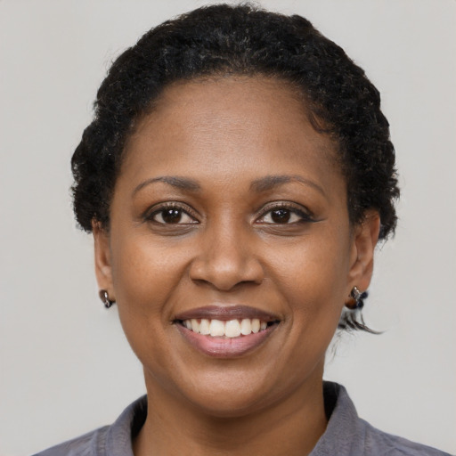 Joyful black adult female with short  black hair and brown eyes