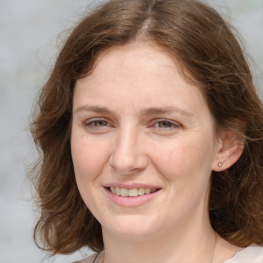 Joyful white young-adult female with medium  brown hair and green eyes