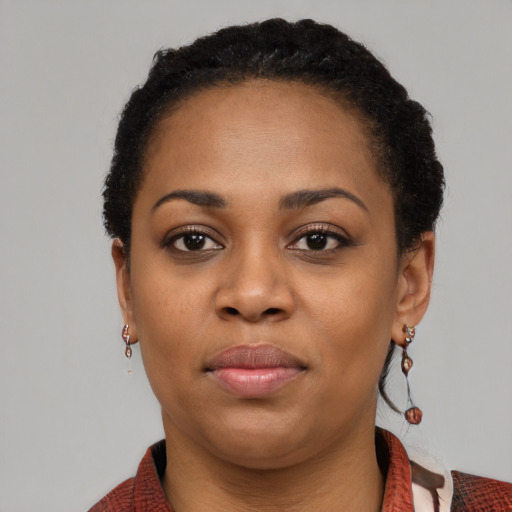 Joyful black young-adult female with medium  black hair and brown eyes