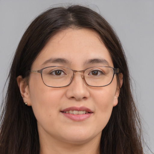 Joyful white adult female with long  brown hair and brown eyes