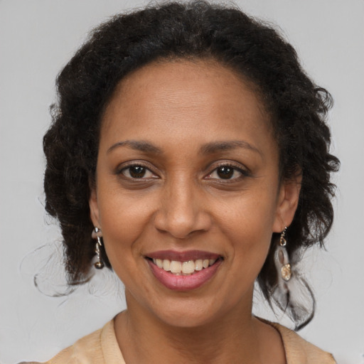 Joyful black adult female with long  brown hair and brown eyes