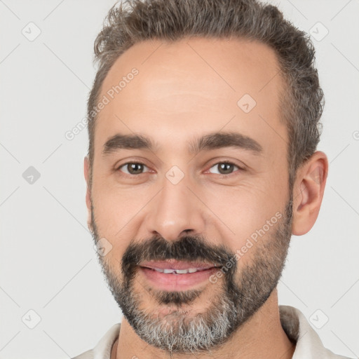 Joyful white adult male with short  black hair and brown eyes