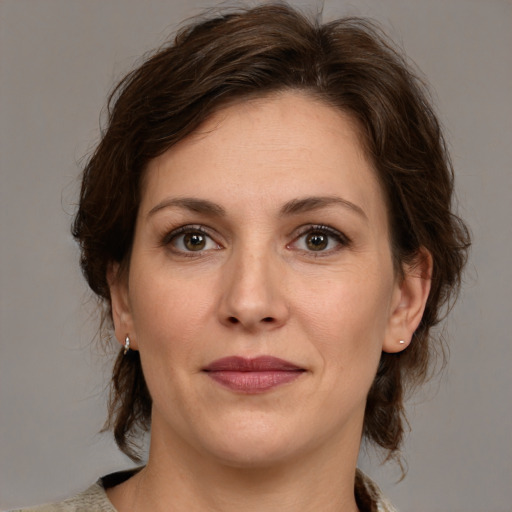 Joyful white adult female with medium  brown hair and grey eyes