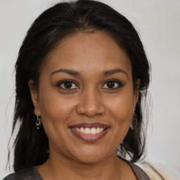 Joyful black adult female with medium  brown hair and brown eyes