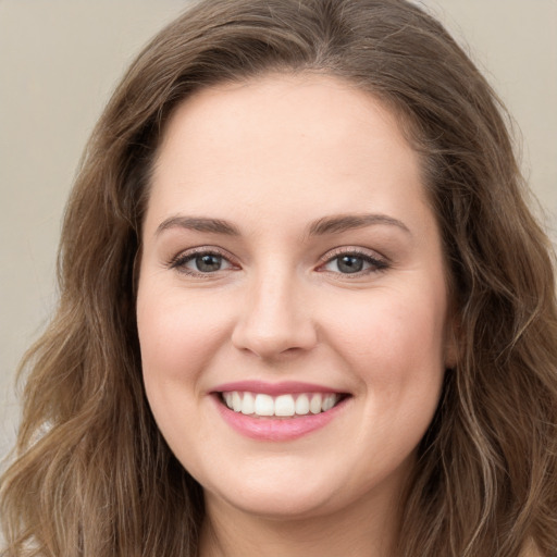 Joyful white young-adult female with long  brown hair and green eyes