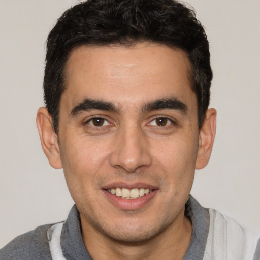 Joyful white young-adult male with short  black hair and brown eyes