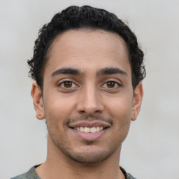 Joyful latino young-adult male with short  brown hair and brown eyes