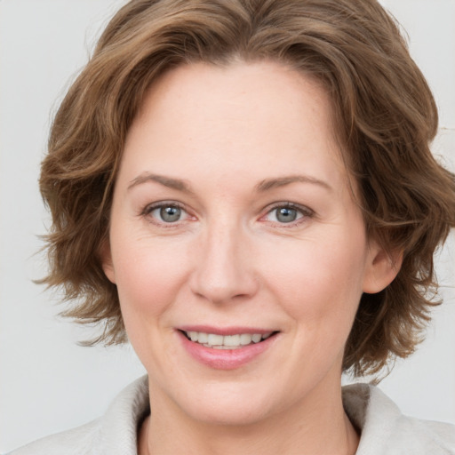 Joyful white adult female with medium  brown hair and grey eyes